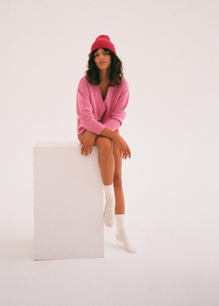 žena s červenou čepicí a růžovým oversized svetrem